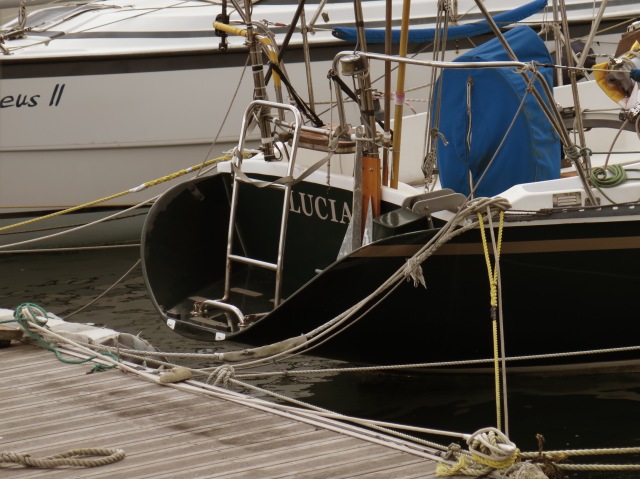 Lucia, black boat, viewed from the back, with a view of the dock